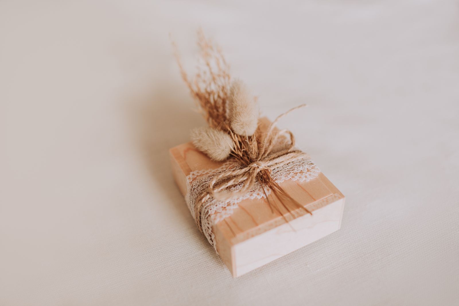 Chiavetta USB in una scatola di legno decorata con pizzo, spago e fiori secchi
