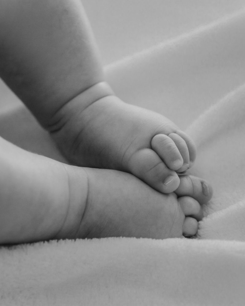 Piedini di un neonato in bianco e nero durante la sessione Casa dolce casa