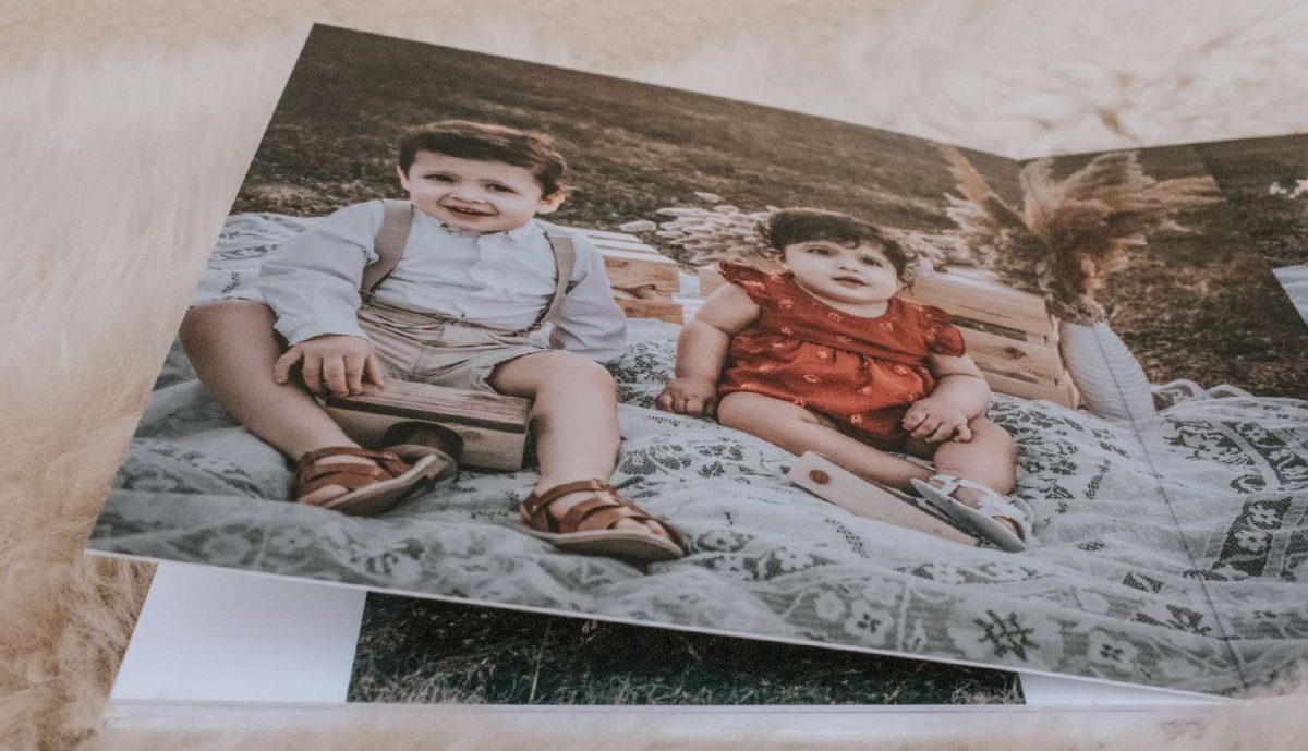 Fotolibro aperto con copertina in tessuto e pagine in carta fotografica