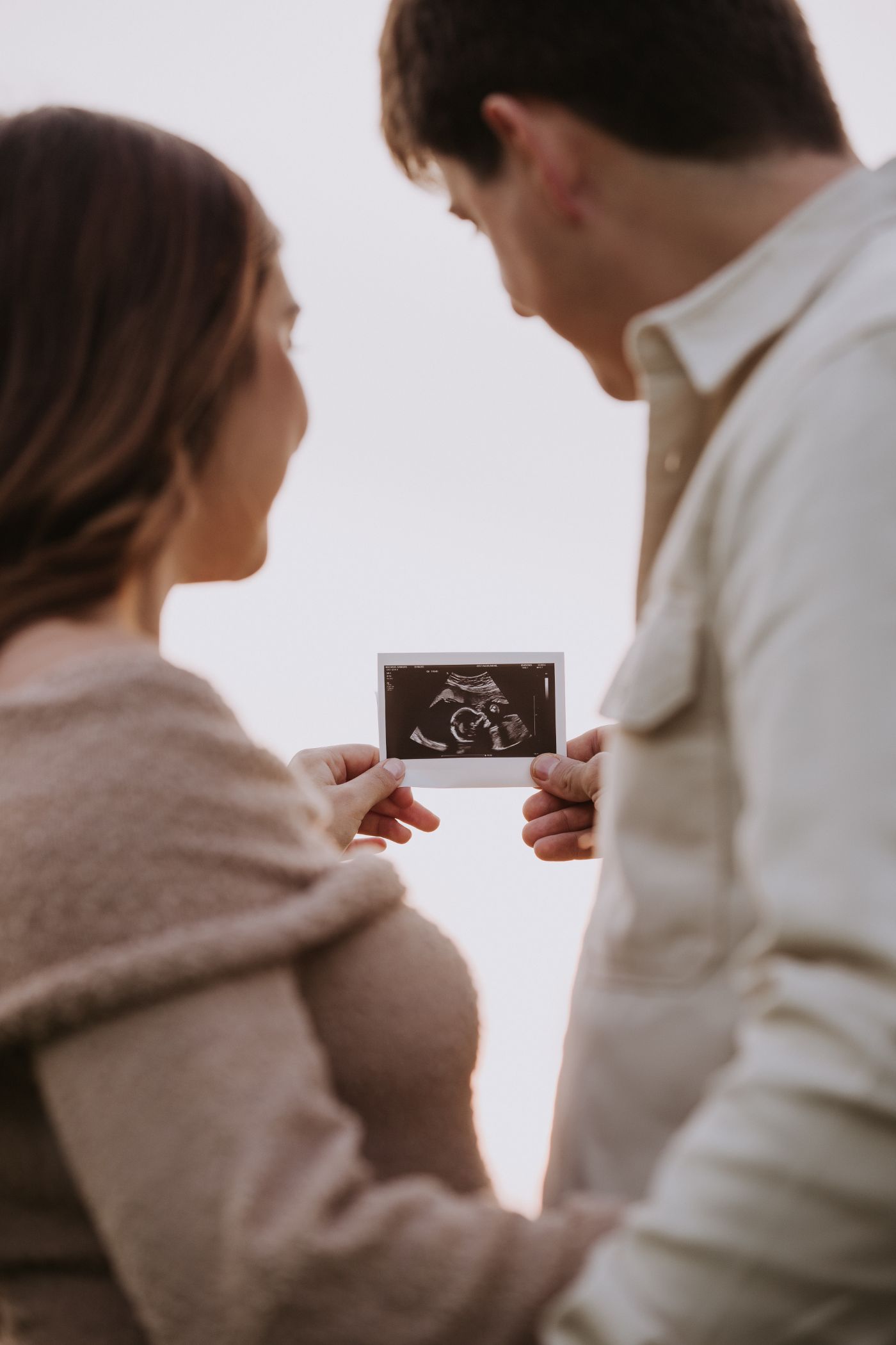 Coppia in attesa che tiene in mano l'ecografia del loro bambino
