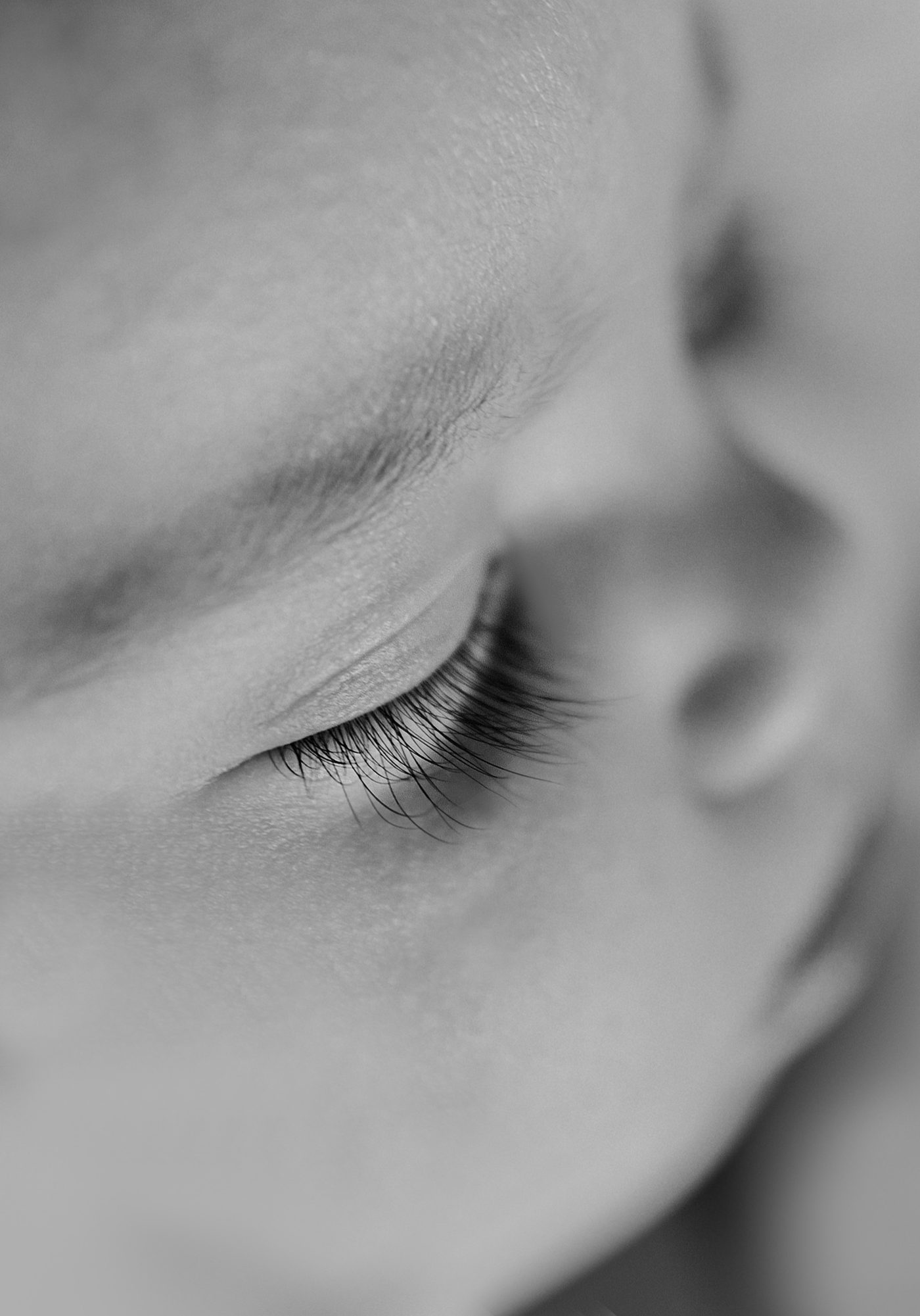Primo piano delle ciglia di un neonato che dorme, in bianco e nero